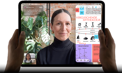iPad Pro, Vorderansicht, Querformat, Farbe Space Schwarz, gerundete Ecken, schwarzer Displayrand, zwei Hände halten es an der linken und rechten Seite, das Display zeigt ein FaceTime Gespräch, das live übersetzt wird, und eine Lernapp zeigt eine Präsentation zum Thema „Vergleichende Mythologie“ mit Text, Diagrammen und handschriftlichen Notizen
