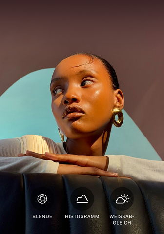Nahaufnahme eines gut beleuchteten Models mit einem bunten Hintergrund, das das Pro Kamera-System mit der Pro Steuerung zeigt: Blende, Histogramm, Weißabgleich